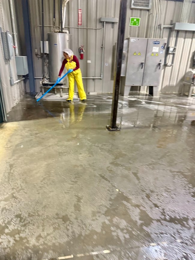 CLEANING SPECIALIST DEEP CLEANS THE FLOOR AT AN INDUSTRIAL FACILITY