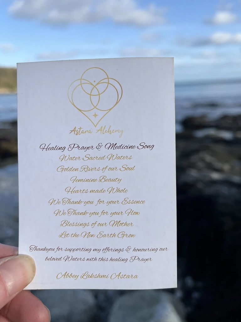 Sacred Water Prayer card held against the Cornish coast for Reiki master training.