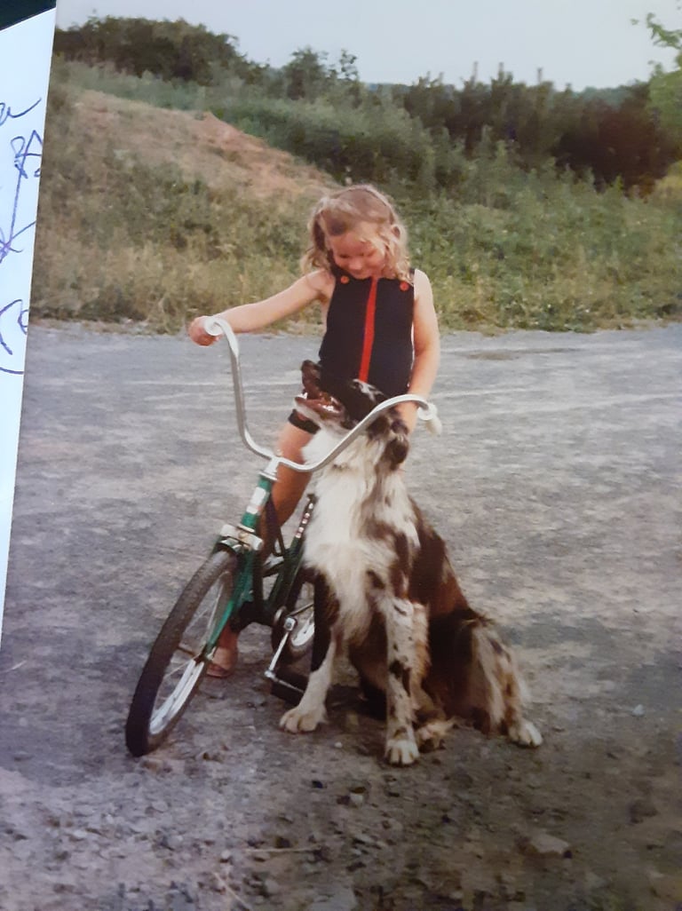 Image of girl on bike with a dog.