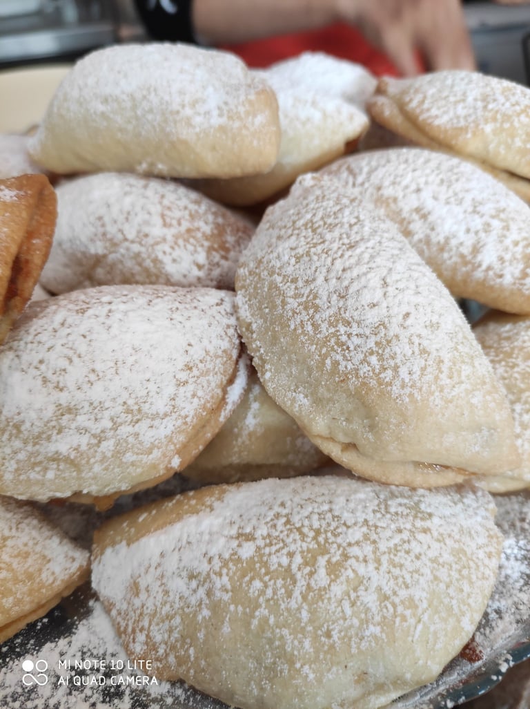 pudra şekeri ile süslenmiş yarım ay şeklinde elmalı kurabiye