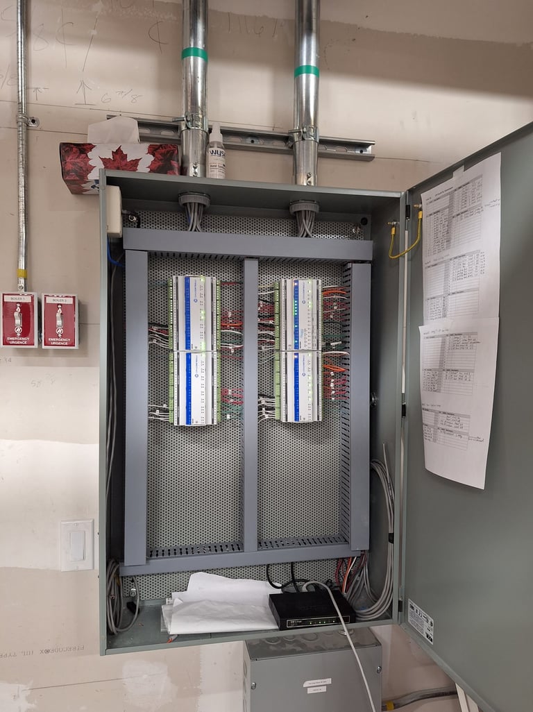 A control panel with iSMA Controlli modules and industrial wiring for HVAC systems.