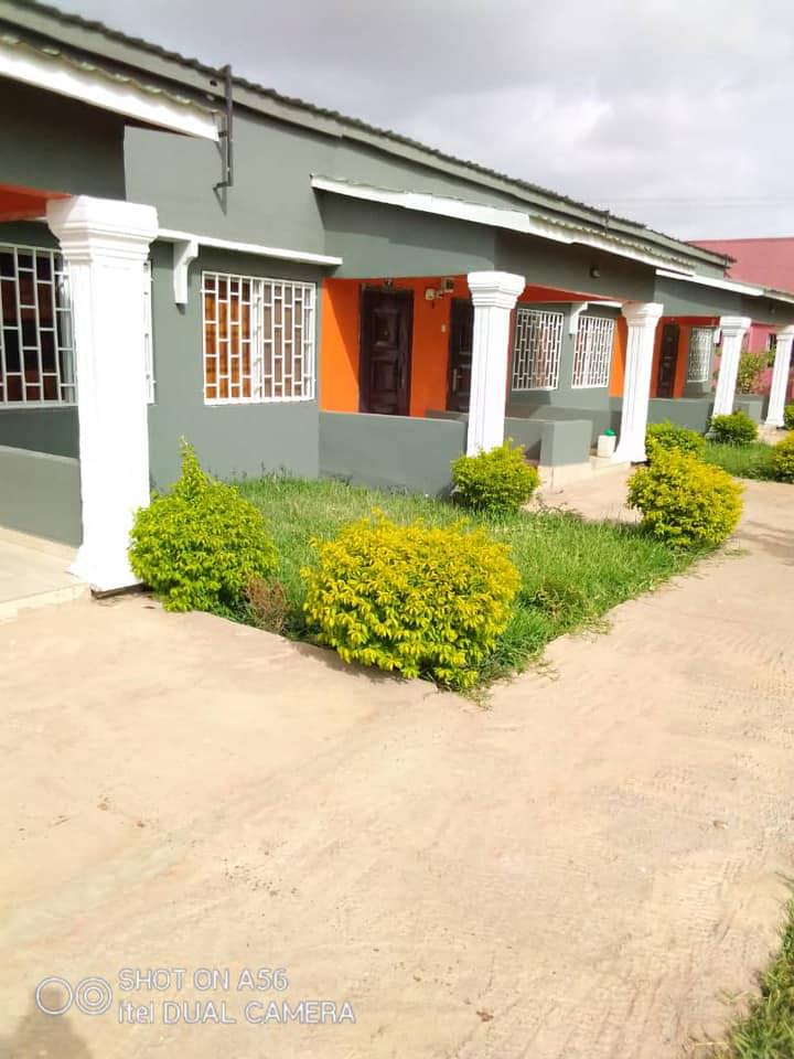 An inviting view of the Kakuba Garden Hotel, surrounded by lush greenery and colorful flowers. The h