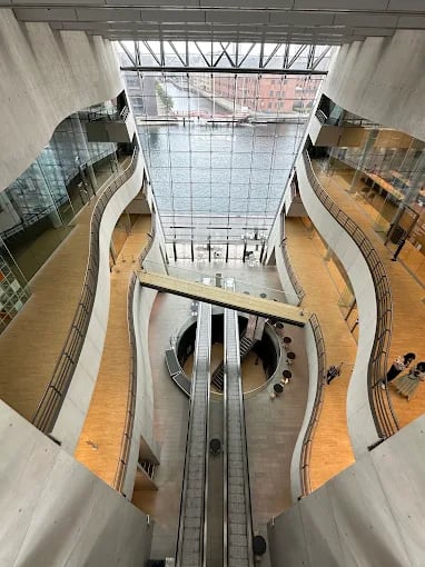 Interior view of the Black Diamond library in Copenhagen featuring modern architecture and escalators.