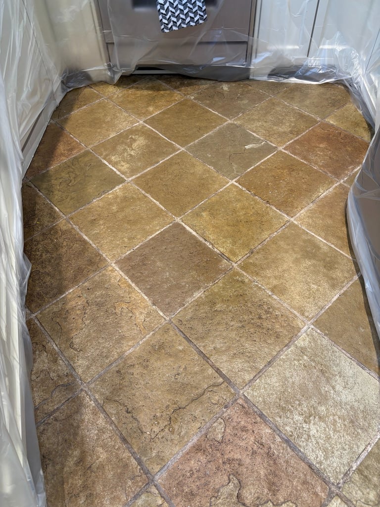 Dirty slate tile floor in kitchen before professional cleaning