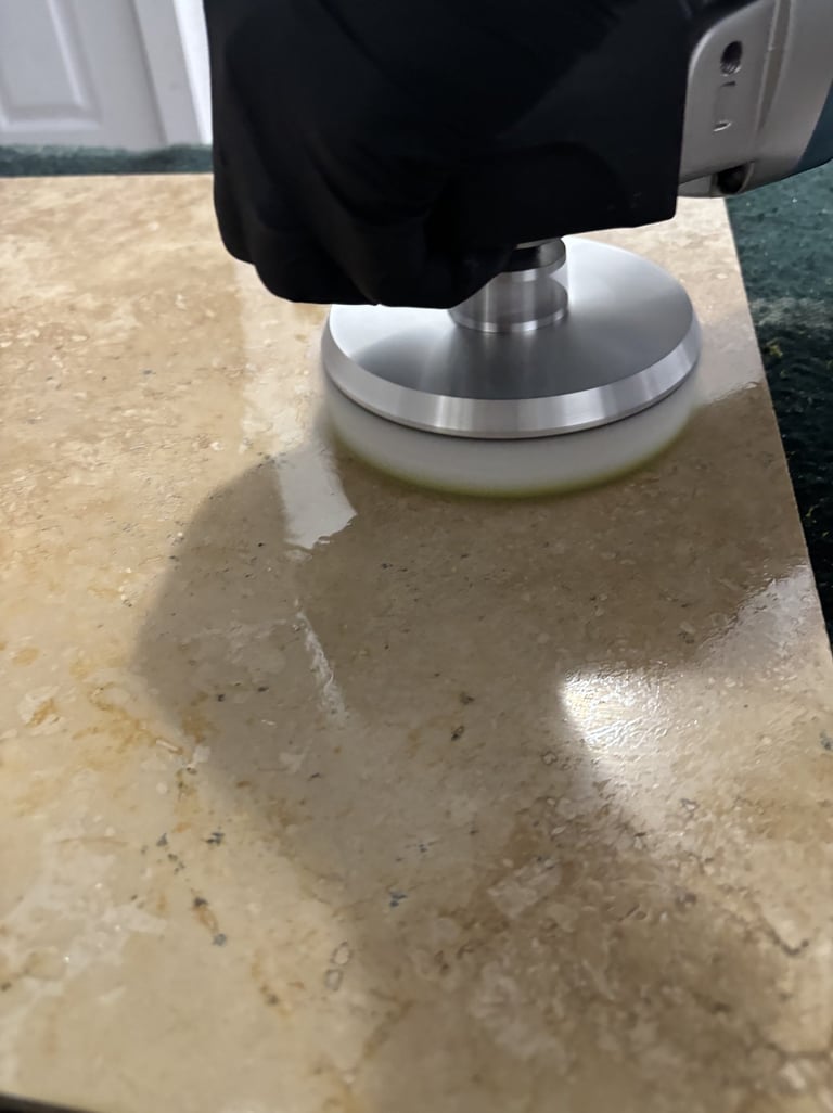 Technician in black glove polishing travertine stone floor surface