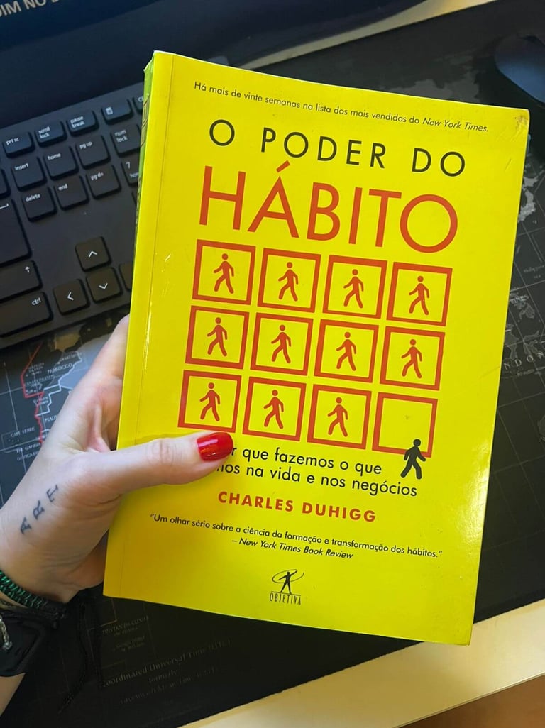 Portuguese edition of the book The Power of Habit by Charles Duhigg with a yellow cover and red icons.