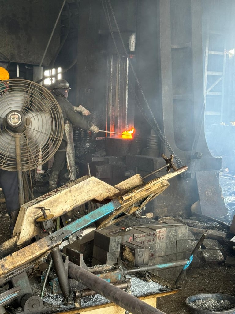 Industrial steel worker using a metal forging press to shape glowing hot molten metal in a factory.