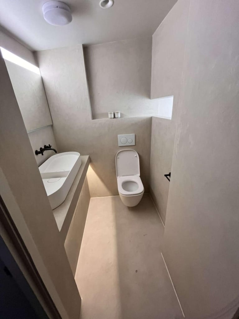 a bathroom with a toilet and a sink fitted by pbp services in droitwich