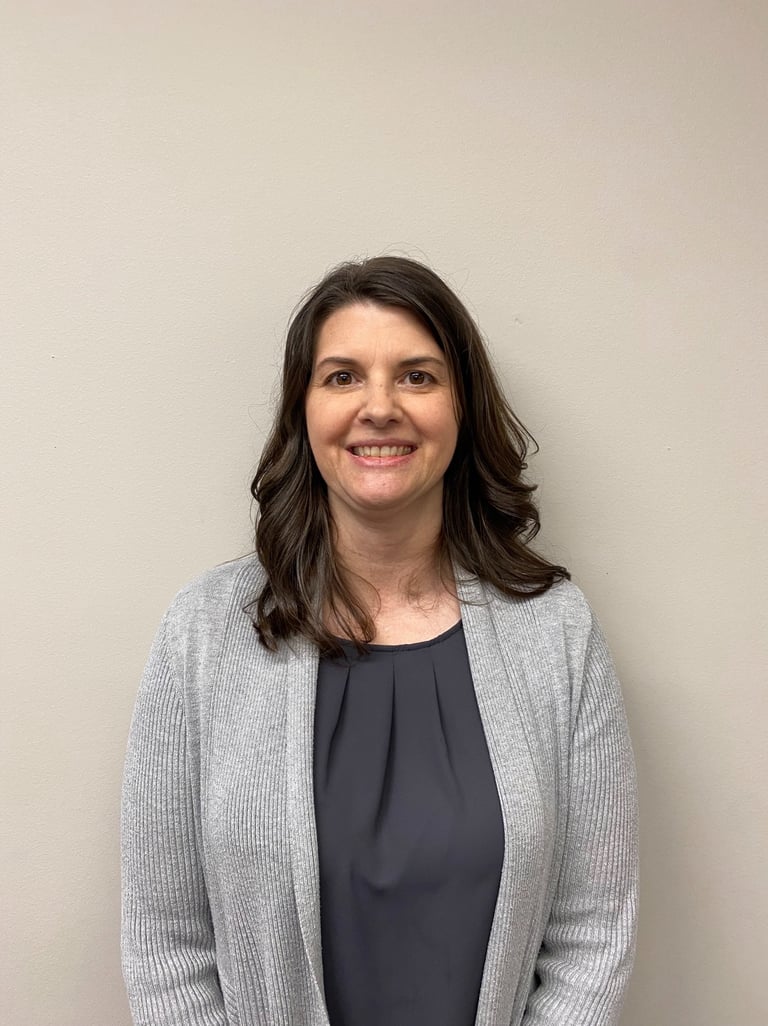 a woman in a gray sweater and black top