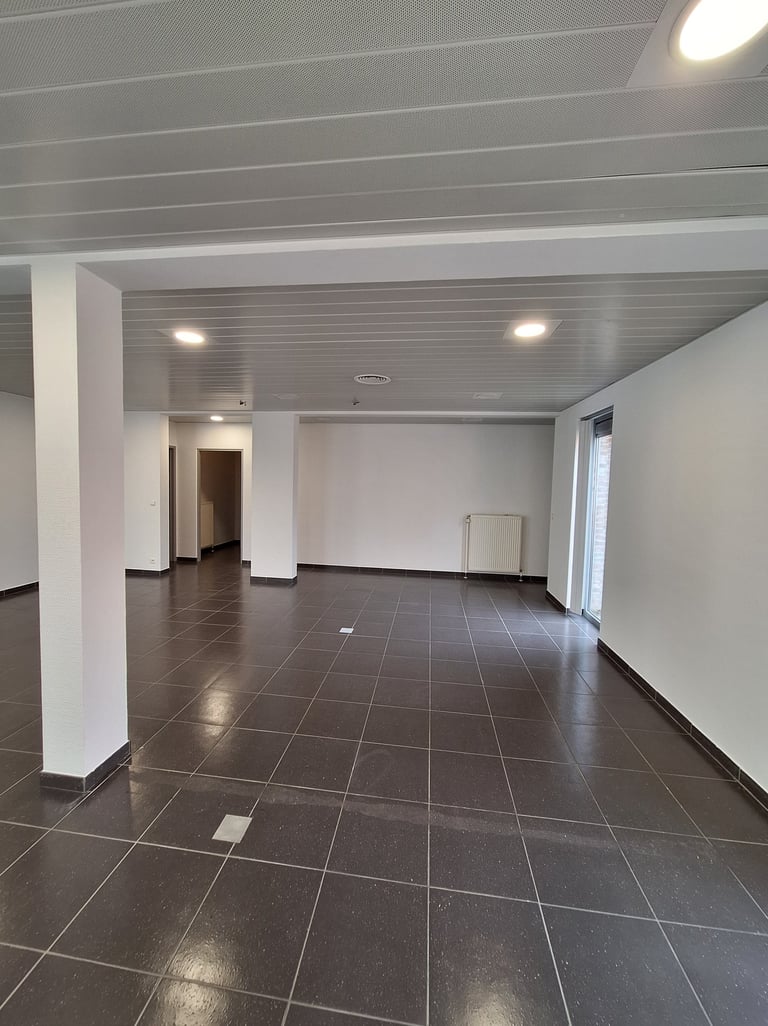 Photo de l'espace central avant transformation avec du carrelage gris anthracite et des murs blanc