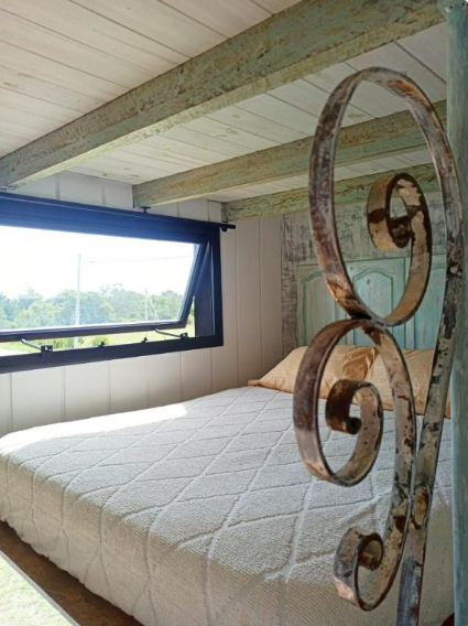Interior luminoso de la tiny house con vista desde la cama