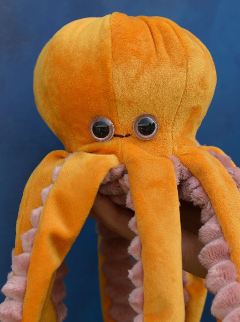 Peluche pieuvre artisanale jaune cousue main sur fond bleu