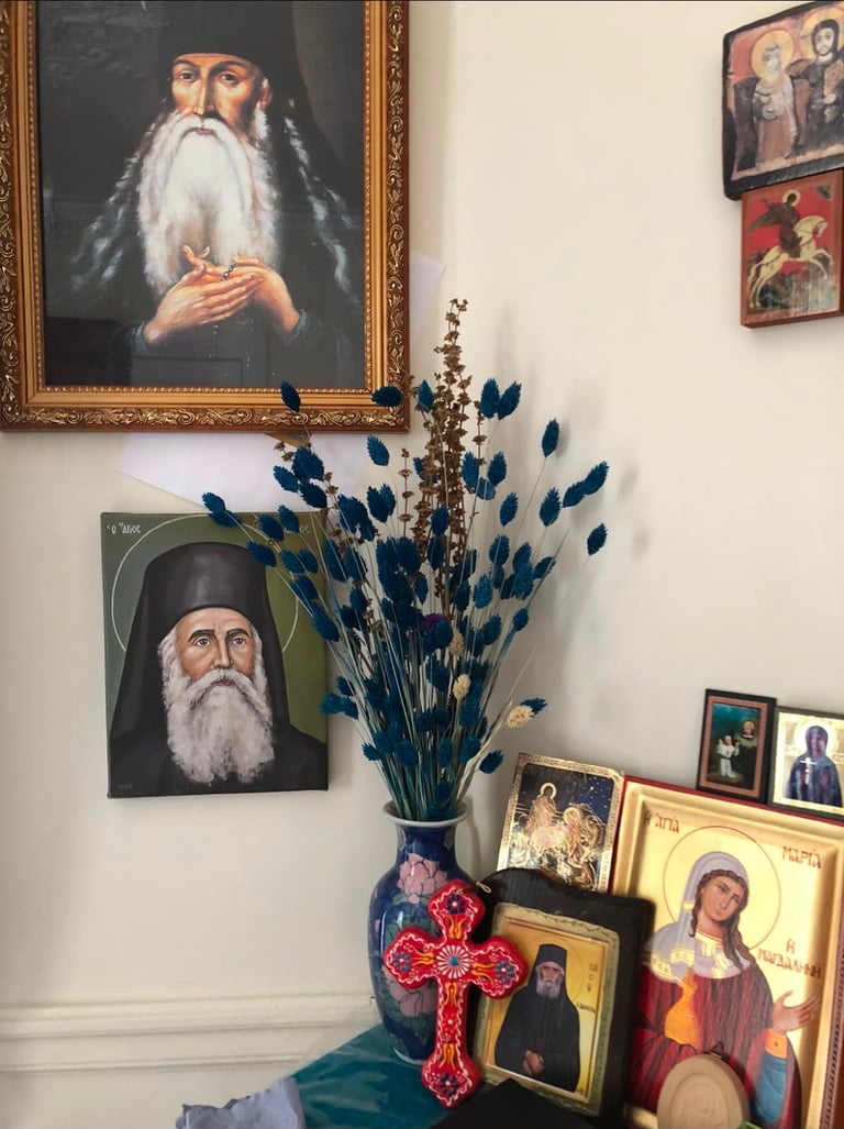 Coin prière de la maison de Berdiaev avec icônes orthodoxes, portrait de saint et vase de fleurs.