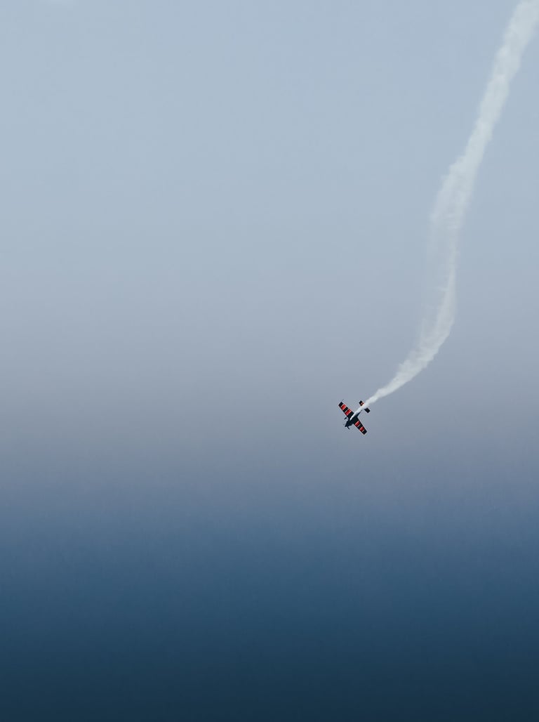 a plane flying in the sky with smoke coming out of it