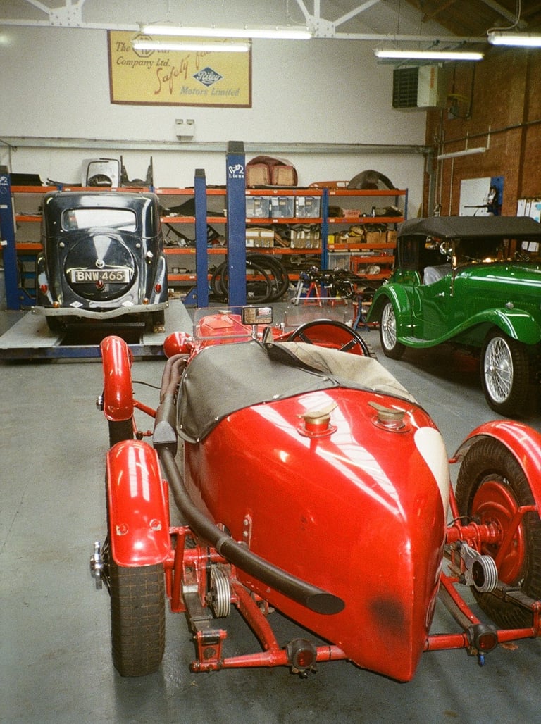 a classic car garage with three vintage cars parked in it
