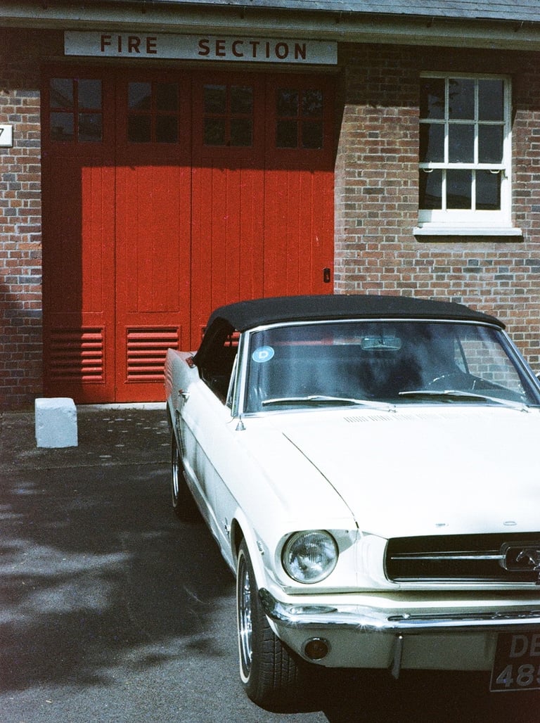 a classic Ford Mustang parked in front of a brick building