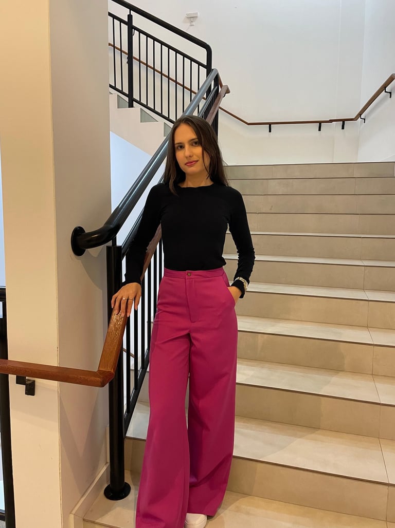 Mulher usando uma calça pantalona  rosa e blusa preta