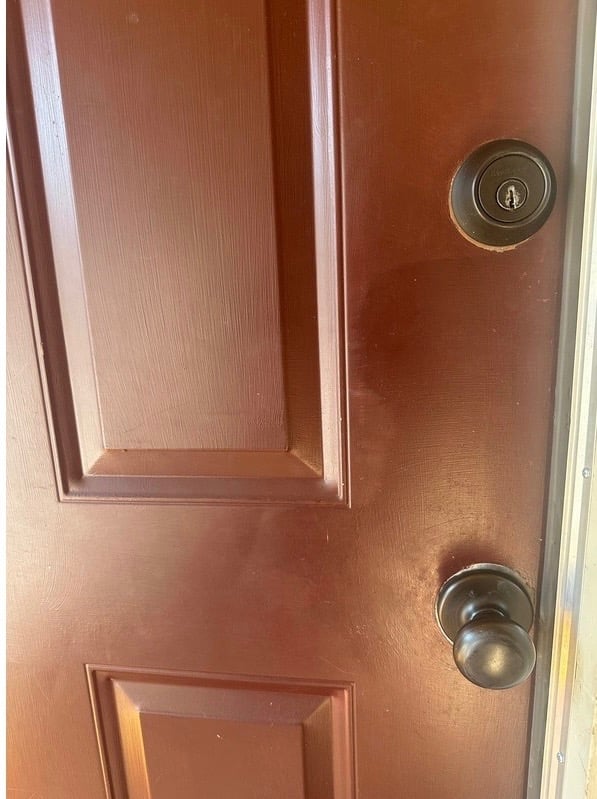 Red home door with deadbolt and knob representing residential locksmith services Candler, NC