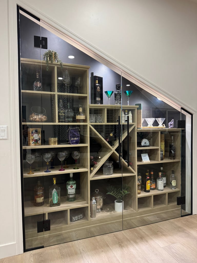 Wine and liquor wall, custom cabinets from California Closets. Under stair storage