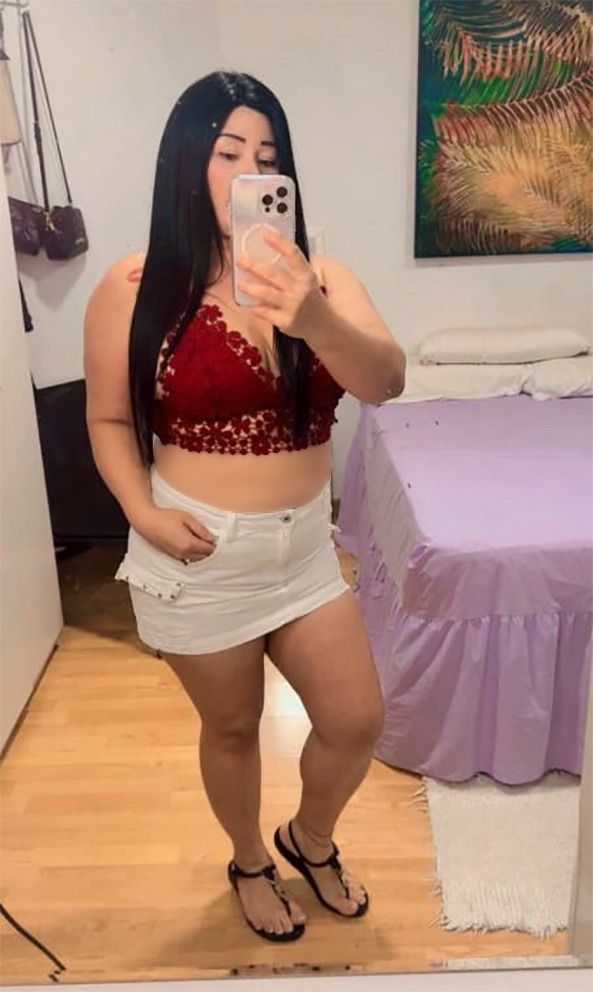 Viky con falda blanca y top rojo, look casual sexy frente al espejo