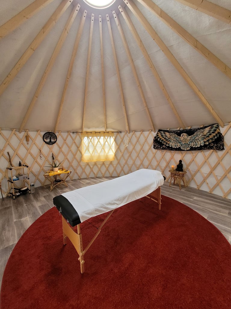 intérieur de la yourte du Chemin de la Chouette avec table de soin