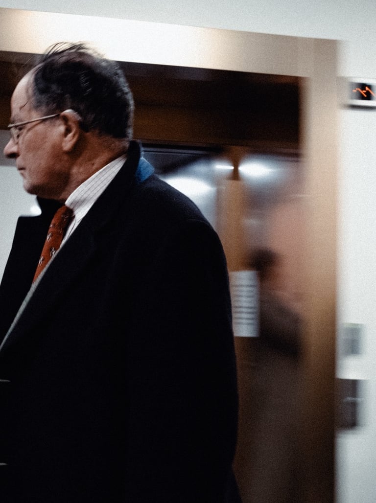 a man in a suit and tie walking through a hallway