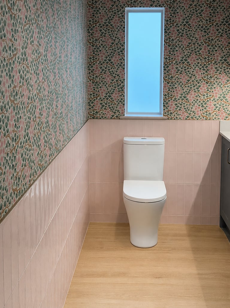 Modern bathroom featuring floral wallpaper, pink vertical tiles, and a white toilet in Brighton.