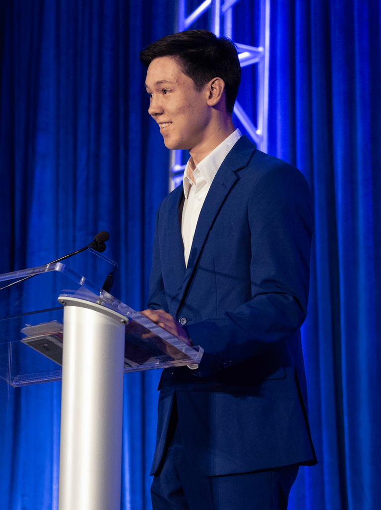 founder, Joseph Phelps in a suit and tie standing at a podium