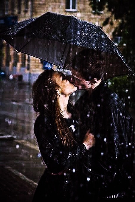 Passionate kiss in rain under the umbrella