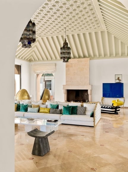 Living room at Villa El Rincon in Marbella featuring sea views, elegant décor, fire place and floor-to-ceiling windows.