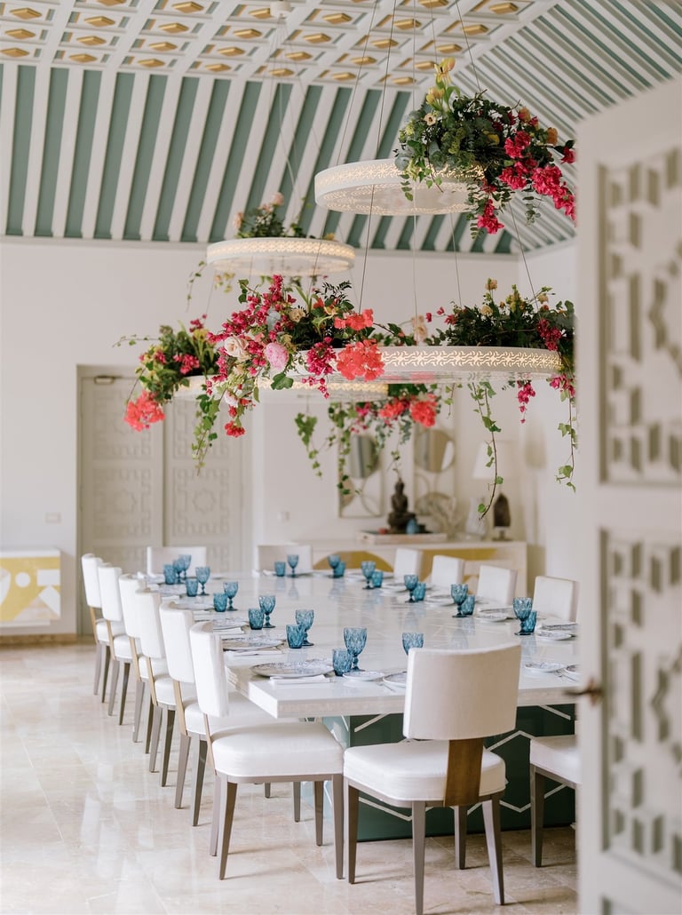Dining room at Villa El Rincon featuring ornate ceilings with hanging lights and floral decorations for a destination wedding