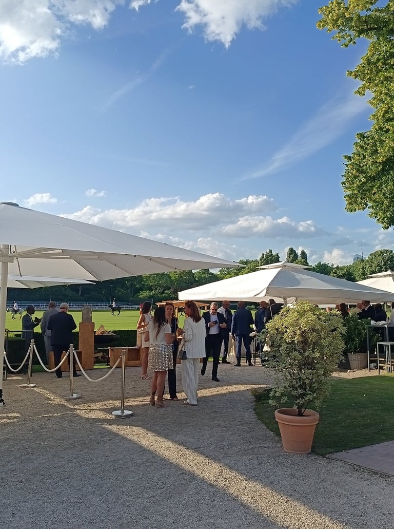 Une fête d'entreprise haute de gamme avec un brasero en plein air, près d'un terrain de polo.