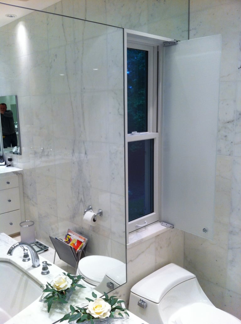 Modern luxury bathroom with white marble walls, a bathtub, and an integrated privacy window shutter.