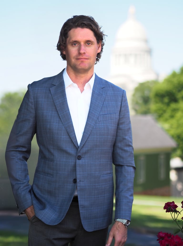 Arkansas Criminal Defense Attorney Kale Ludwig stands in front of the Arkansas Capitol Building. 