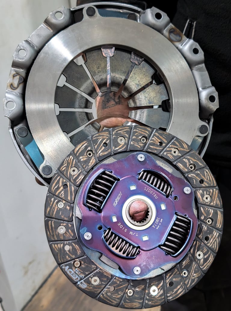 A high-performance Exedy clutch kit featuring a purple pressure plate and friction disc.