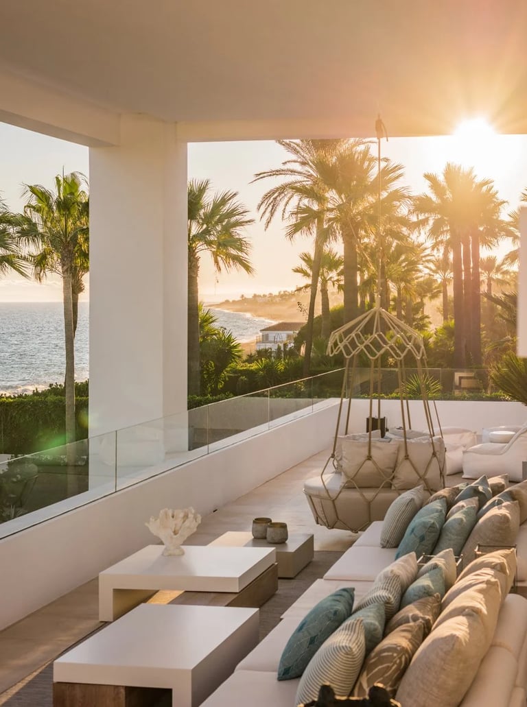 Covered terrace seating area overlooking the coastline at sunset