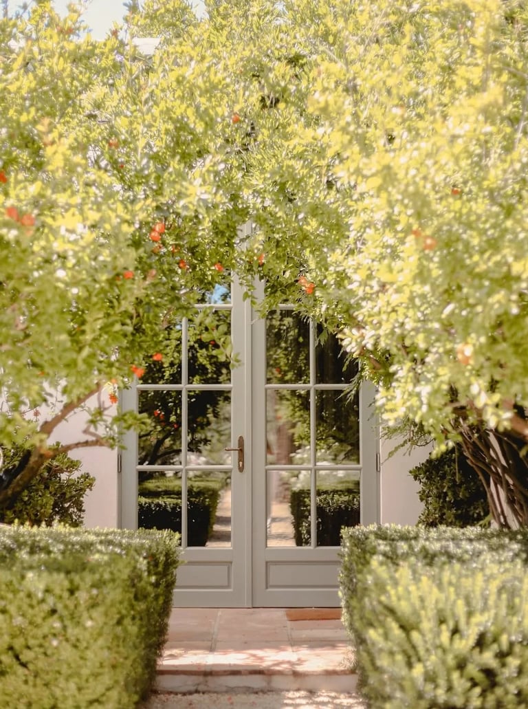 Garden entrance with glass doors framed by flowering trees