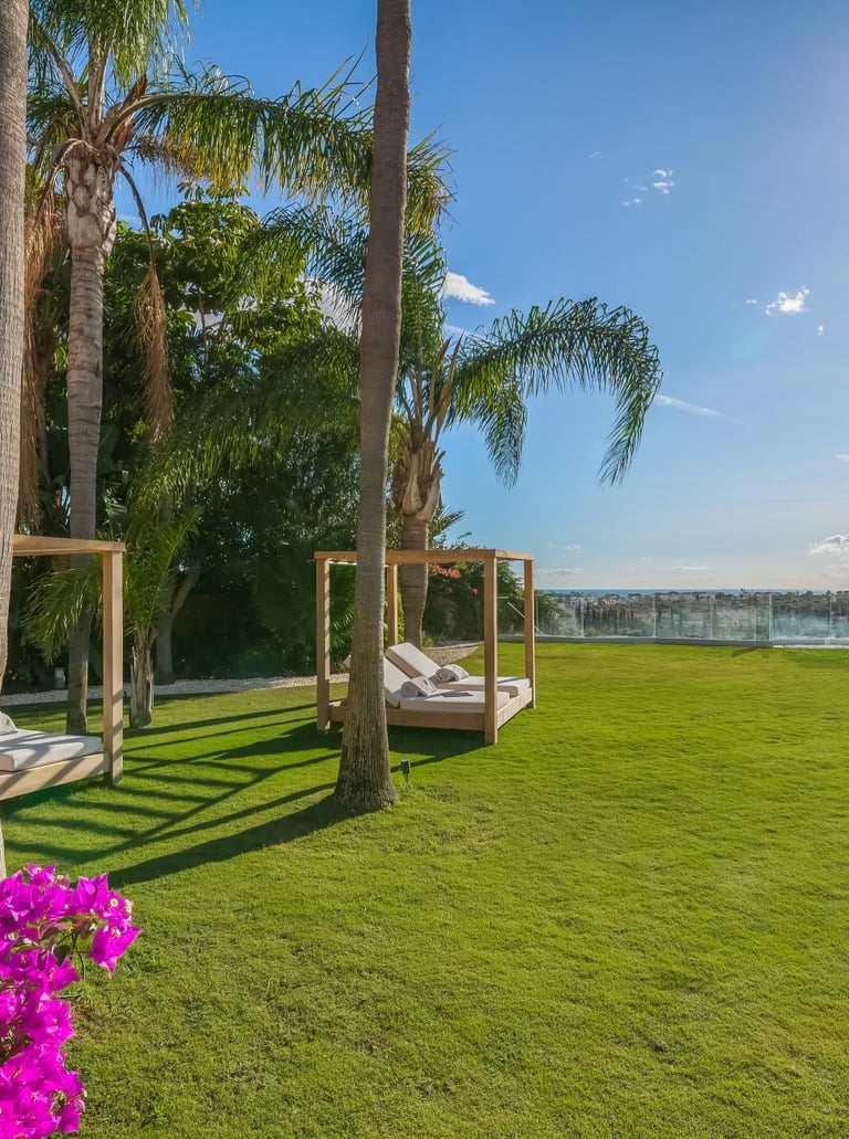Flat garden lawn with daybeds and panoramic sea views