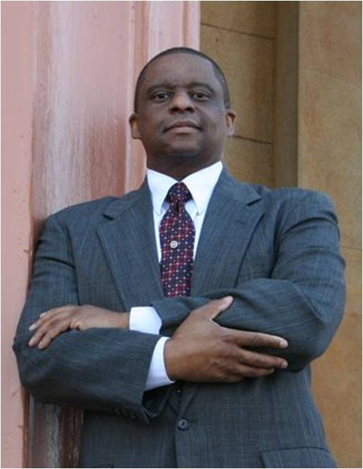 Mark T Stewart in a suit and tie is standing in front of Old Courthouse
