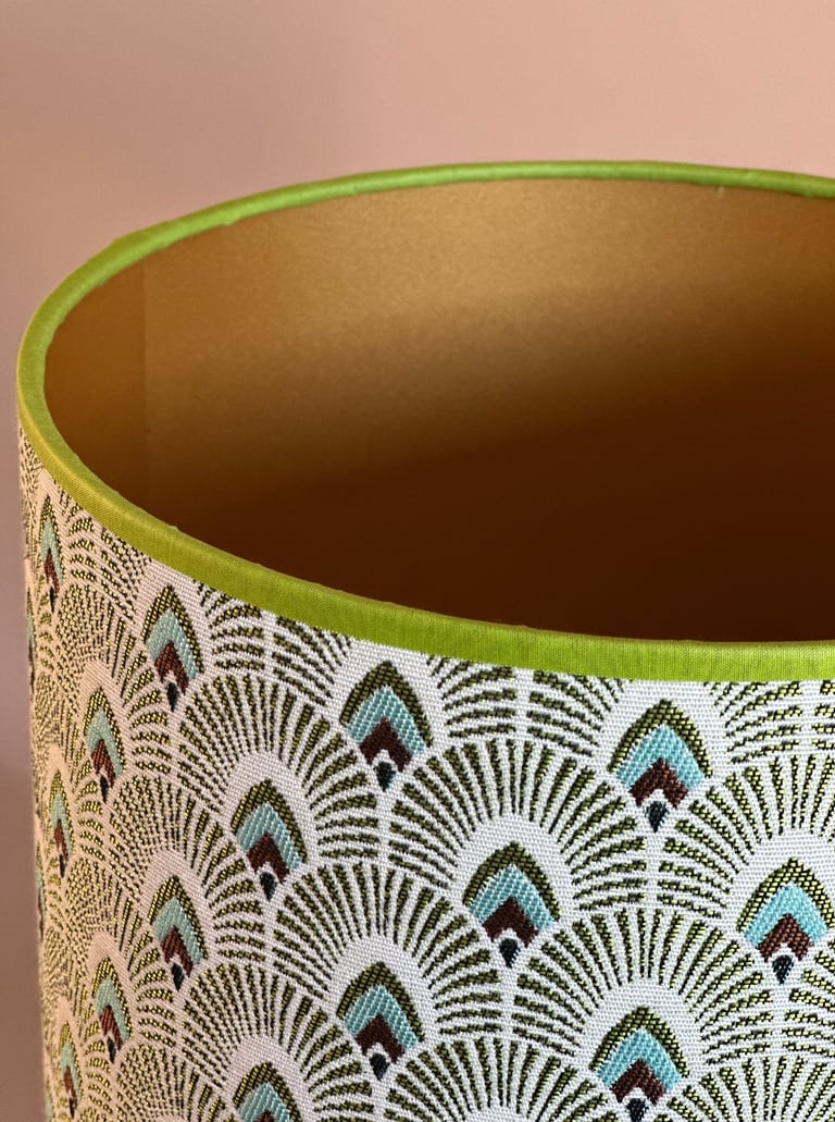 Green and gold art deco lampshade with fan pattern jacquard fabric and green trim.
