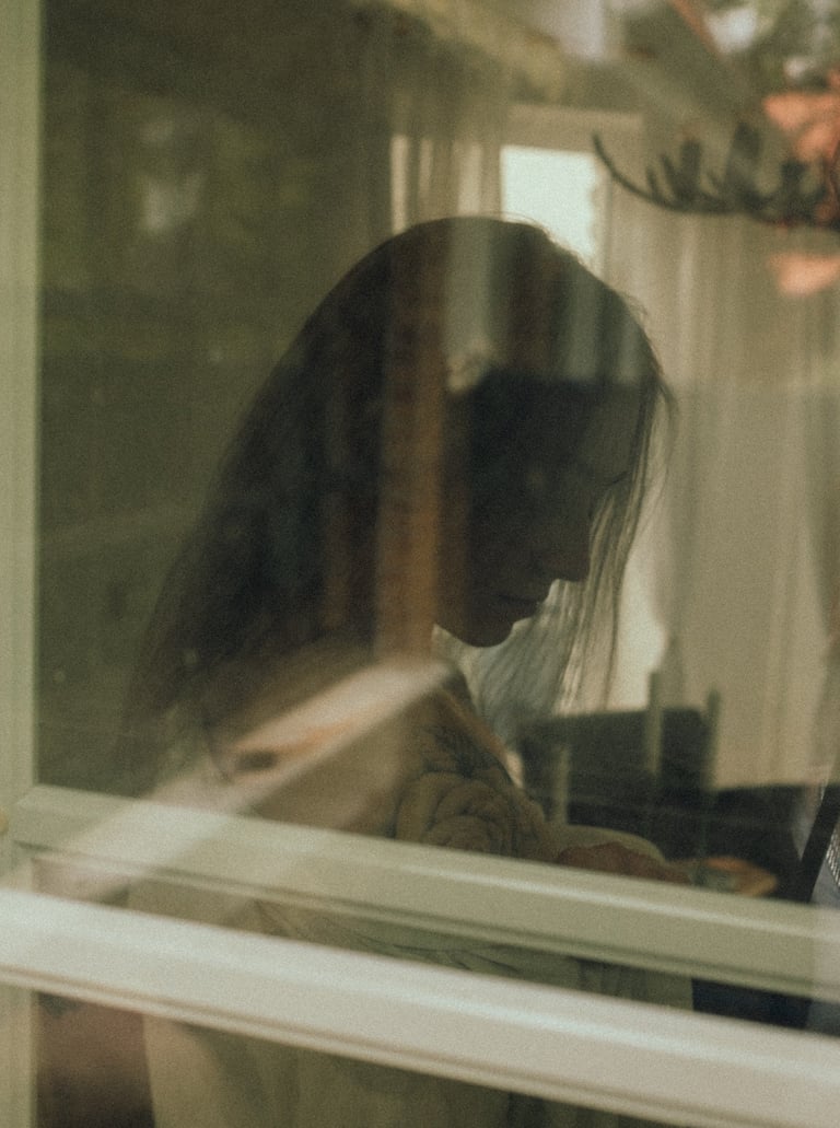 Künstlerische Portraitfotografie Rheine: Doppelbelichtung am Fenster, Reflexion einer Frau.