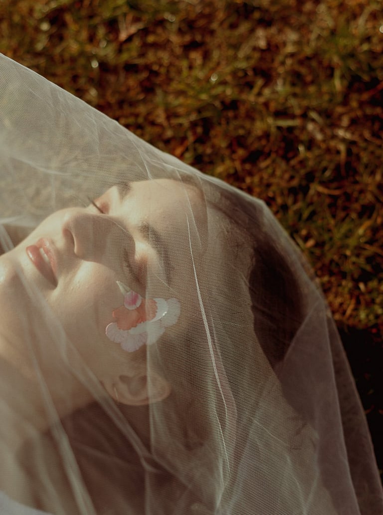 portrait rapproché d'un visage féminin maquillé recouvert d'un voile en tulle transparent