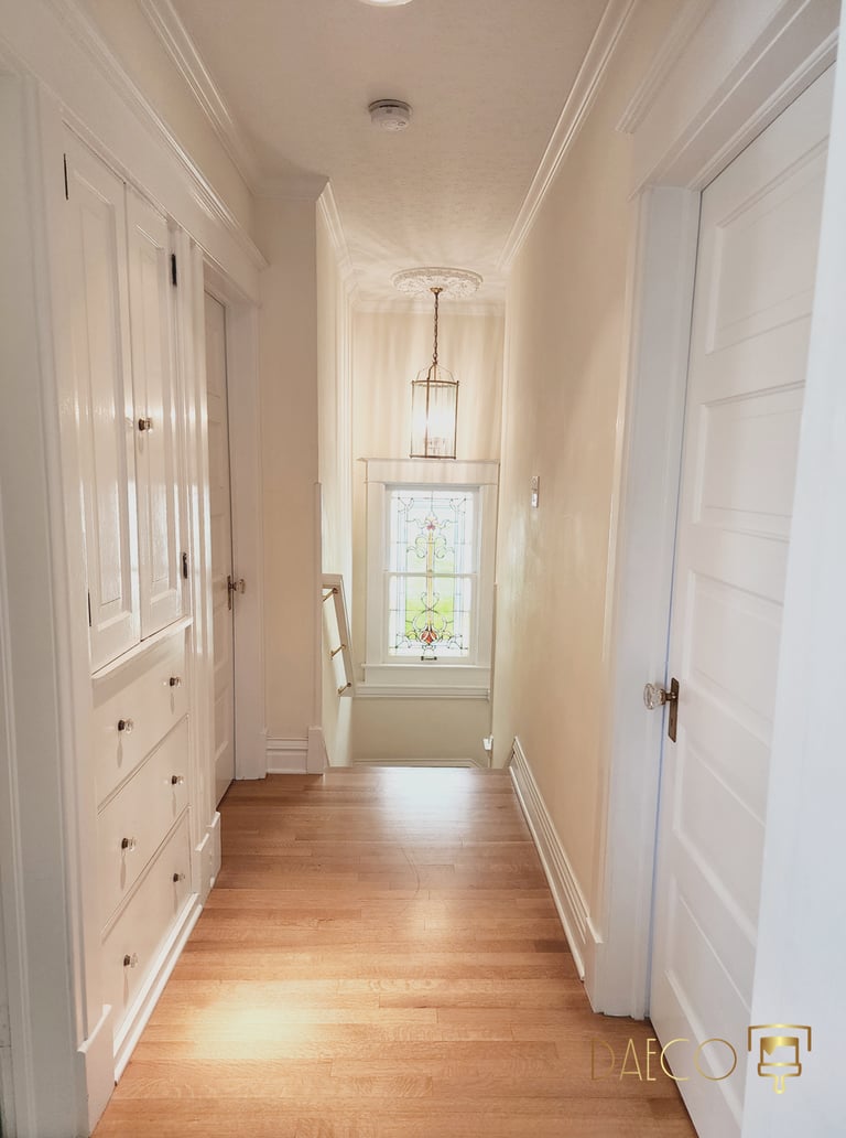 a hallway with white doors and a window, wood floors elegant interior hallway