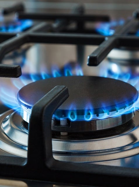 a gas stove top with blue flames on it