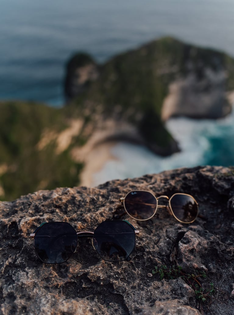 a pair of sunglasses and sunglasses on a rock