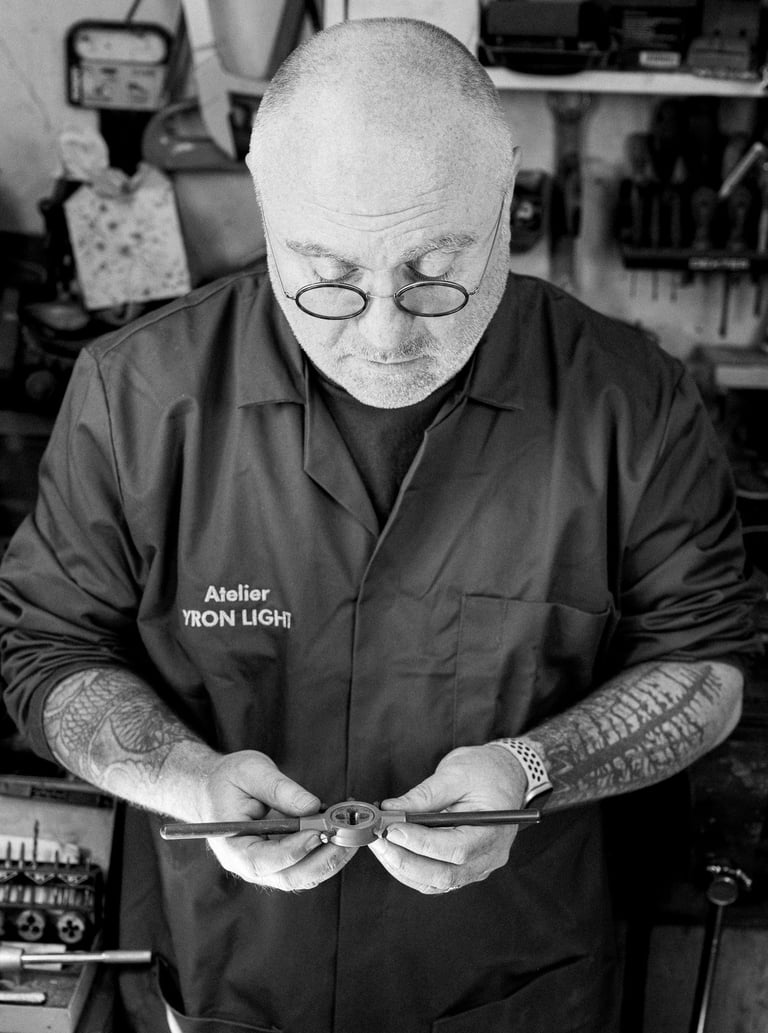 Artisan YronLight dans son atelier tenant une pièce de lampe à la main