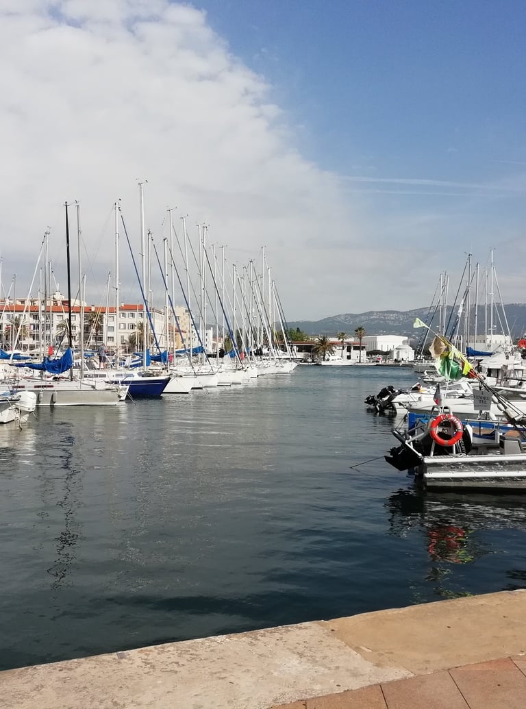 Port de la Seyne, Toulon, avec bateaux à voile amarrés et monts du toulonnais au fond