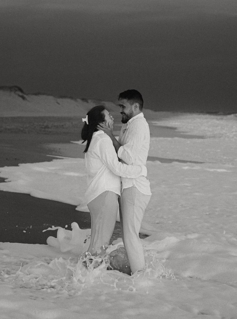 Photographie noir et blanc d'un couple qui s'enlace les pieds dans l'eau plage de Sauveterre en Vendée par Romain DANIEL