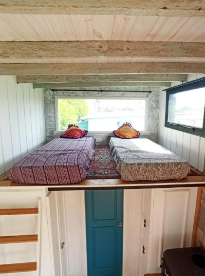 Camas con vistas al parque arbolado, en alojamiento tiny house a metros del mar