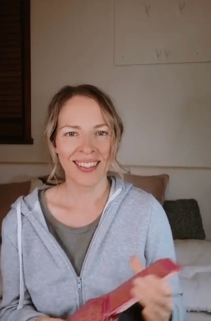 Natalie holding the Five of Pentacles reversed in a live tarot reading.